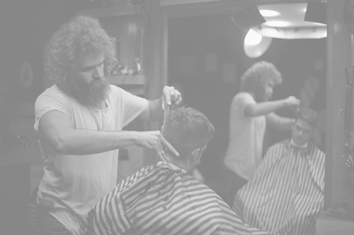 person having hair cut by a barber